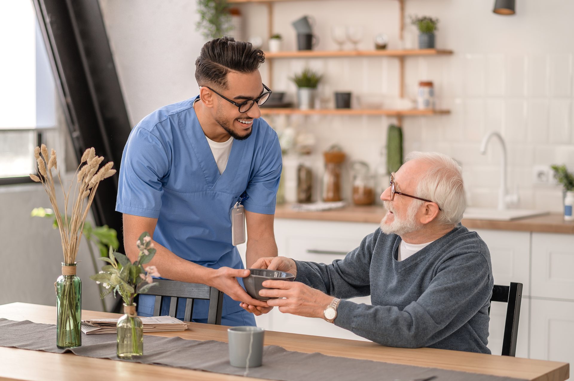 A healthcare professional sharing a warm moment with an older adult at home